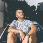 man-in-white-and-blue-crew-neck-t-shirt-sitting-on-top-of-1053811