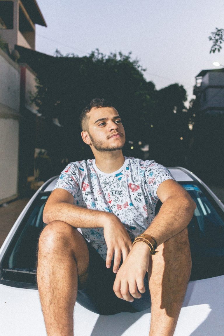 man-in-white-and-blue-crew-neck-t-shirt-sitting-on-top-of-1053811
