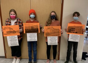 Students from Smiths Falls District Collegiate Institute hold pictures of residential schools with attributed Truth and Reconciliation Calls to Action Recommendations. 