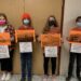 Students from Smiths Falls District Collegiate Institute hold pictures of residential schools with attributed Truth and Reconciliation Calls to Action Recommendations. 