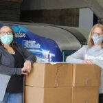 #2 Carilyne and Kimberly with a skid of carton food hampers 3