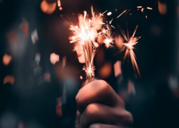 person holding a sparkler in macro photography