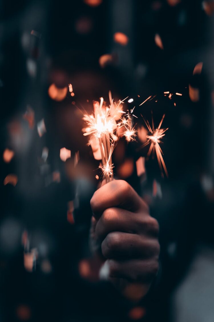 person holding a sparkler in macro photography