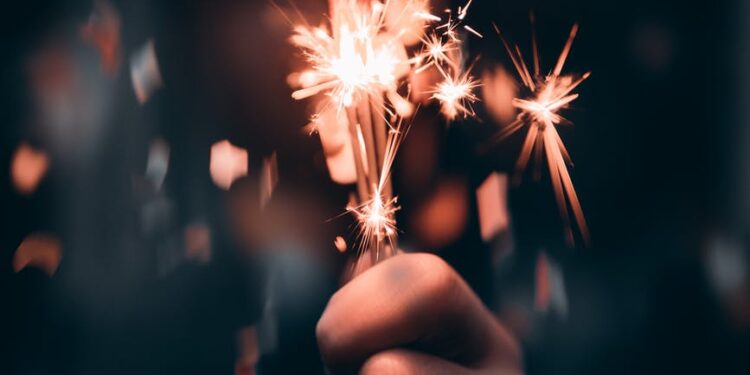 person holding a sparkler in macro photography