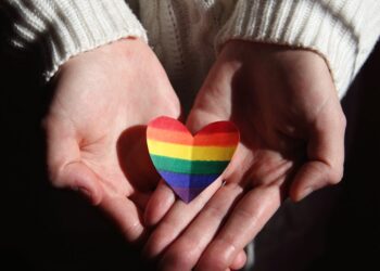person holding multi colored heart shaped ornament
