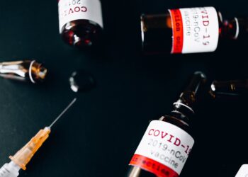 three small glass bottle and a syringe