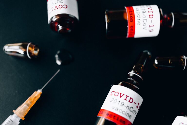 three small glass bottle and a syringe