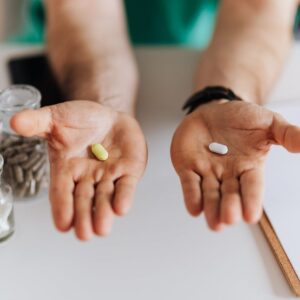 crop doctor showing pills to patient in clinic