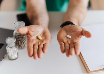 crop doctor showing pills to patient in clinic