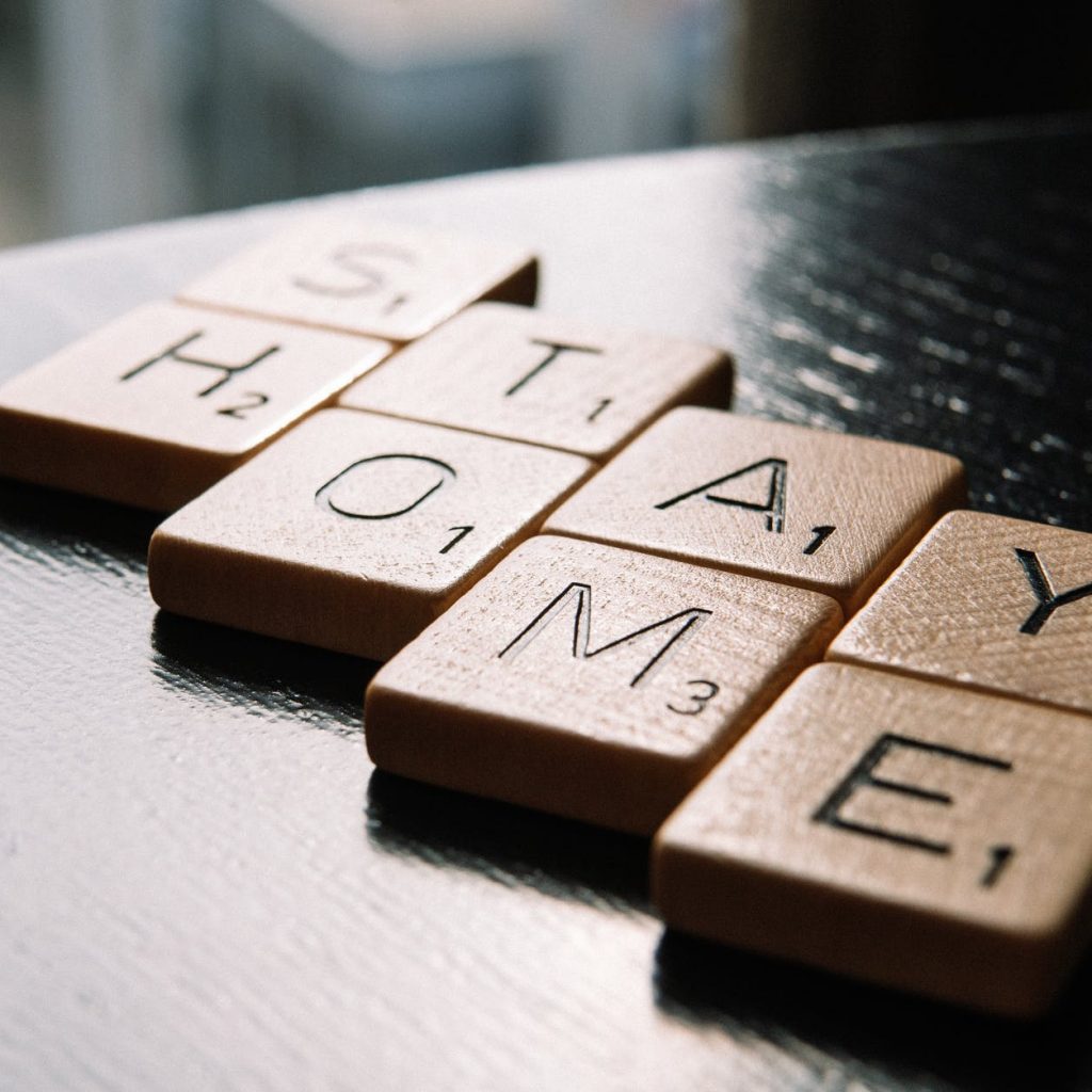 letter tiles arranged in text stay home on table