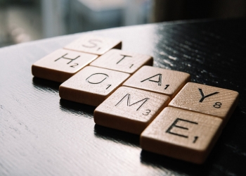 letter tiles arranged in text stay home on table