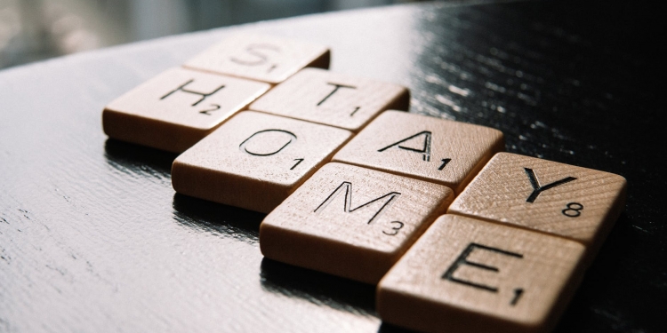 letter tiles arranged in text stay home on table