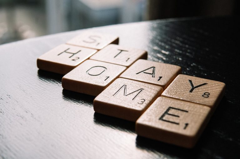 letter tiles arranged in text stay home on table