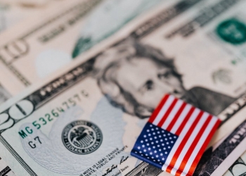 stack of usa money and national flag