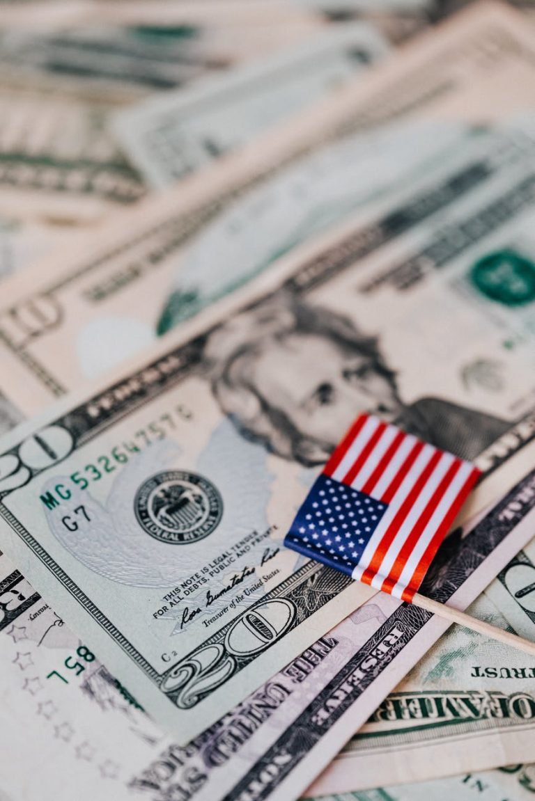 stack of usa money and national flag