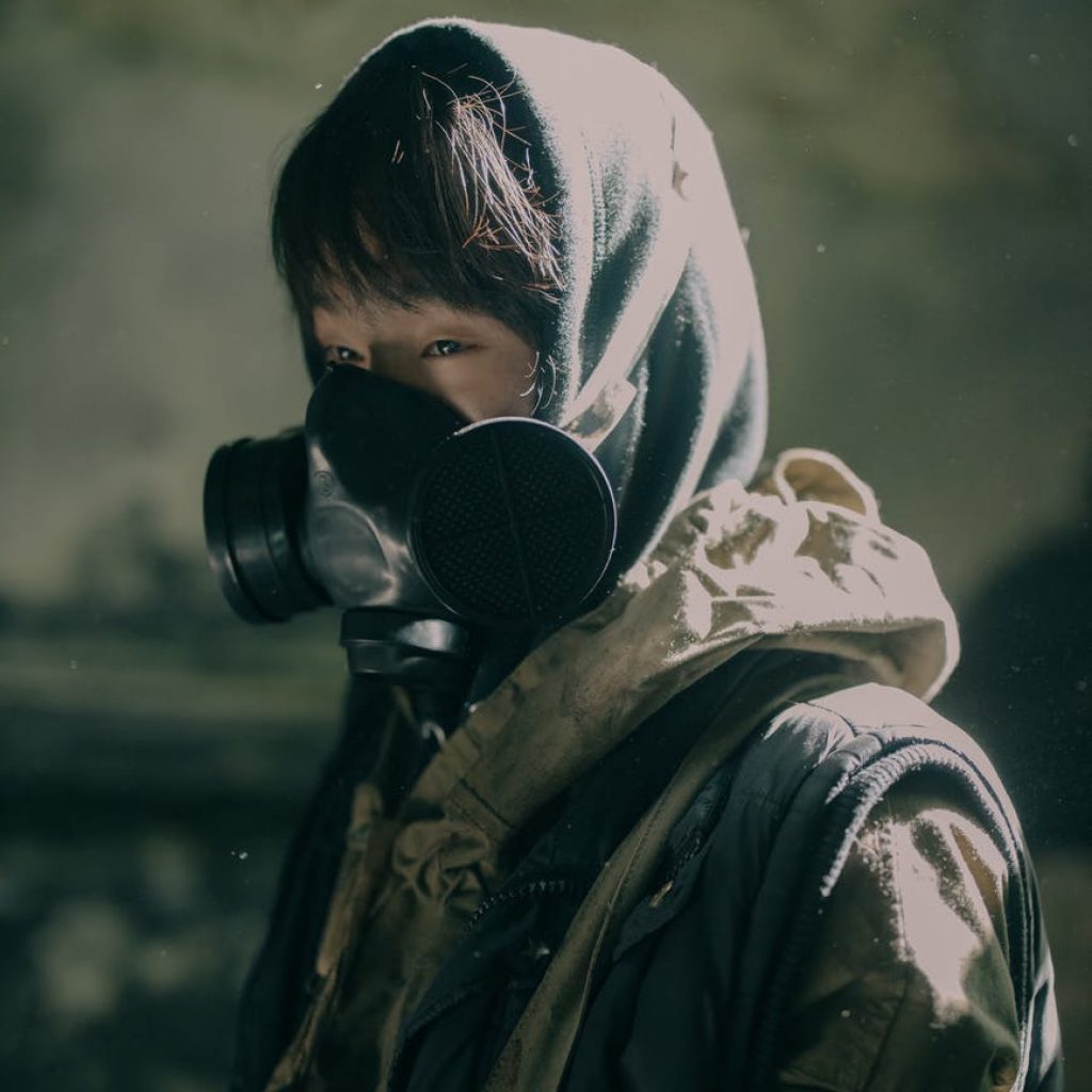 person in black and white hoodie wearing black gas mask