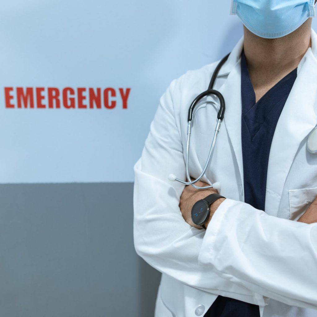woman in white scrub suit wearing blue face mask
