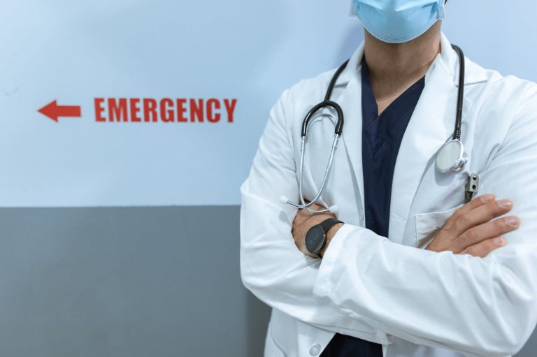 woman in white scrub suit wearing blue face mask