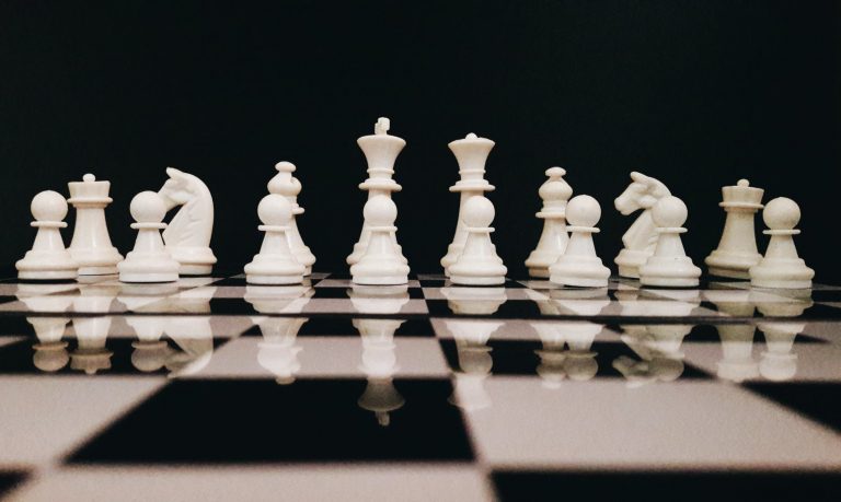 white chess piece on top of chess board