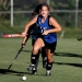 woman wearing blue and black jersey holding field hockey
