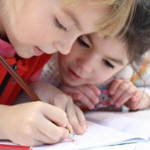girls on desk looking at notebook