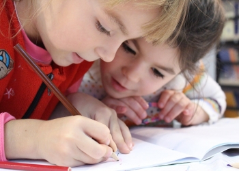 girls on desk looking at notebook
