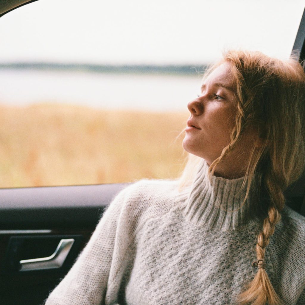 woman in sweater sitting inside a car