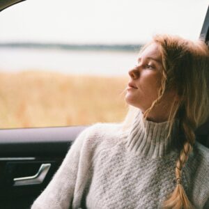 woman in sweater sitting inside a car