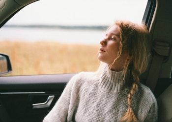 woman in sweater sitting inside a car