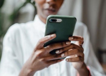 black woman messaging on modern cellphone