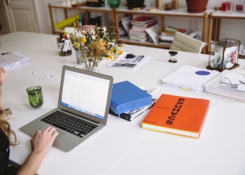 photo of orange book beside laptop