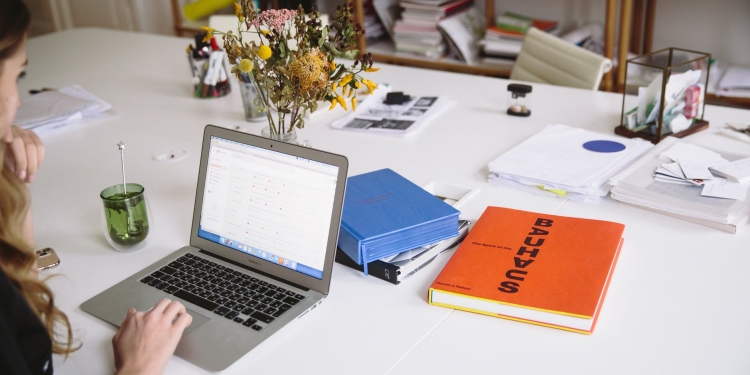 photo of orange book beside laptop