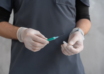 person in black shirt holding green and white pen