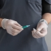 person in black shirt holding green and white pen