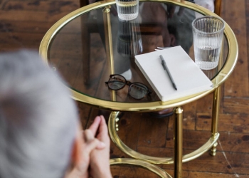 woman in black long sleeve shirt sitting on brown wooden chair