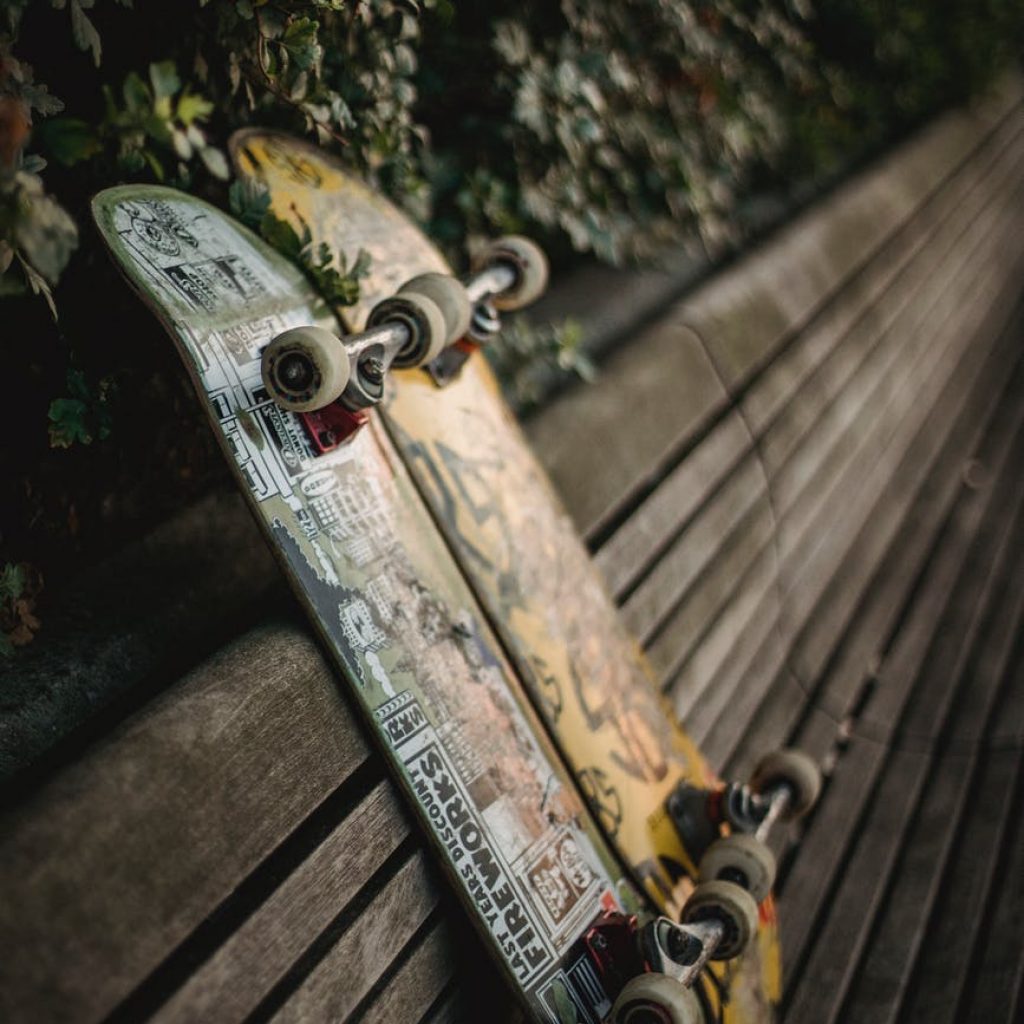 skateboards placed on wooden bench in green park