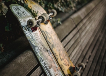 skateboards placed on wooden bench in green park