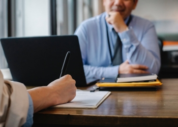 woman filling job application form in office with boss