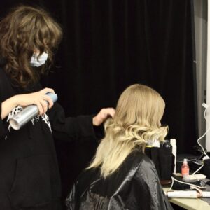 hairdresser making hairdo for client in dressing room