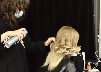hairdresser making hairdo for client in dressing room
