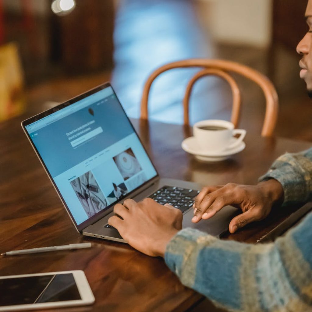 crop man working on laptop in kitchen