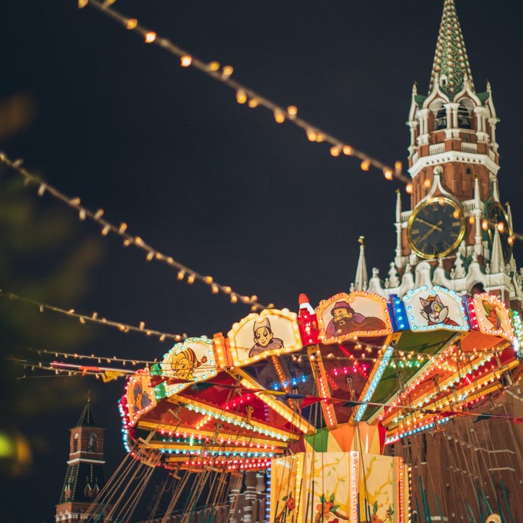 colorful luminous carousel against kremlin on red square at night