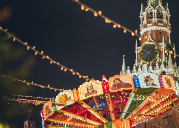 colorful luminous carousel against kremlin on red square at night