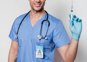 cheerful tattooed doctor with syringe in uniform