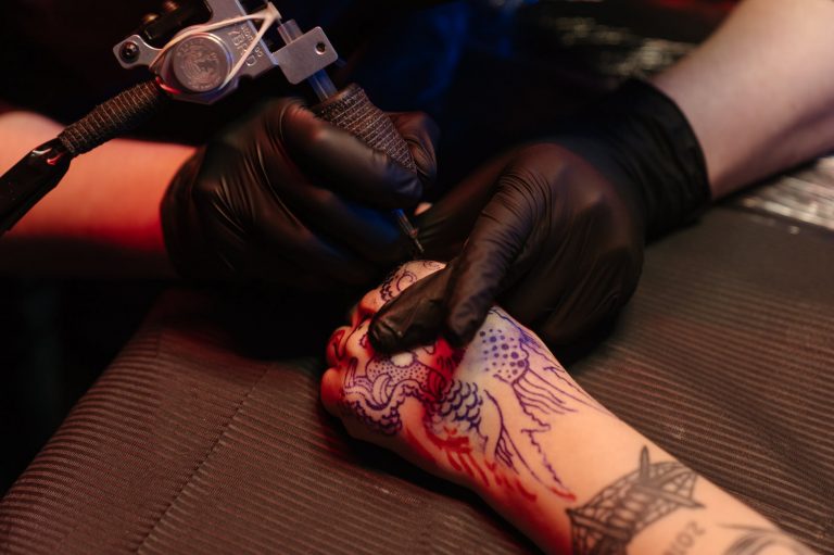 person with red rose tattoo on right arm