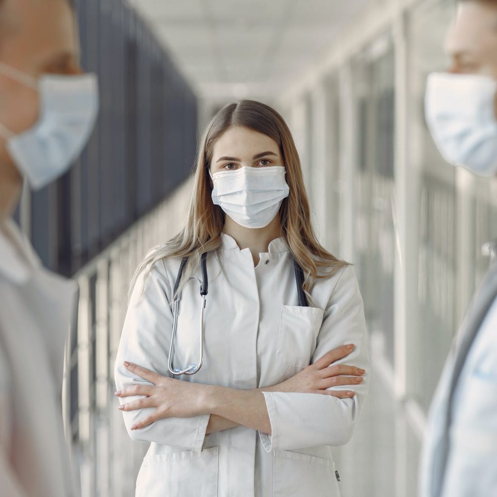 woman in white coat wearing white face mask