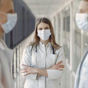 woman in white coat wearing white face mask