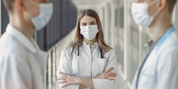 woman in white coat wearing white face mask