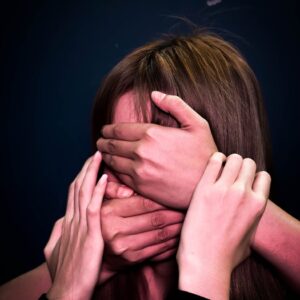 people covering face and mouth of helpless woman