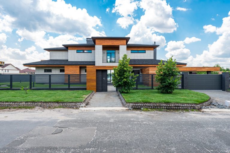 exterior of fenced modern villa in suburb area